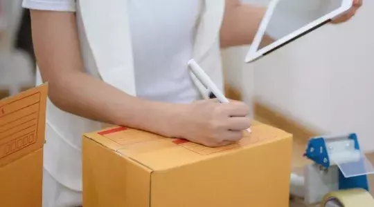 vendeuse devant un carton avec tablette